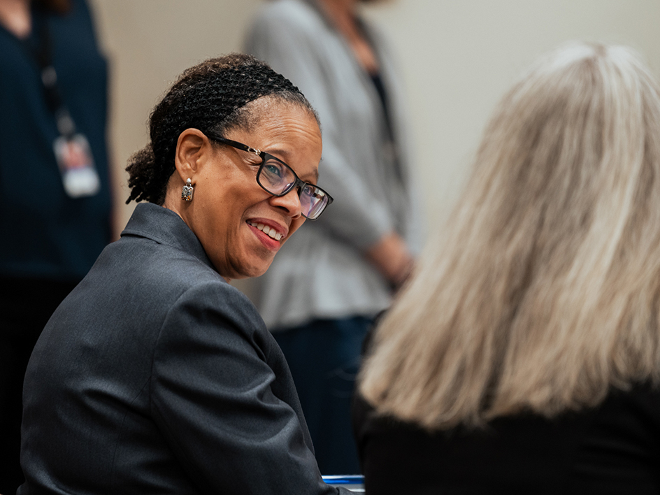A woman smiles and looks at the woman next to her